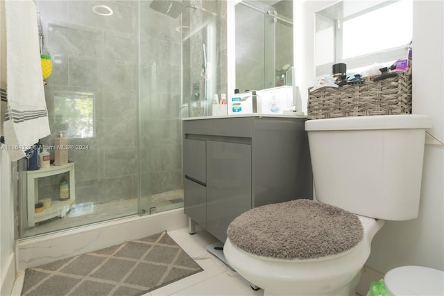 bathroom with vanity, a shower with shower door, toilet, and tile patterned floors