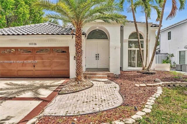 mediterranean / spanish-style home featuring central AC and a garage