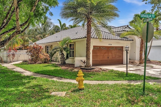 mediterranean / spanish home featuring a garage and a front yard