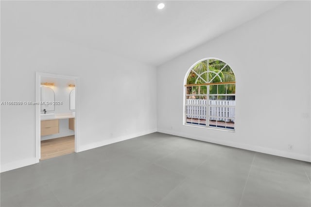 unfurnished room featuring lofted ceiling