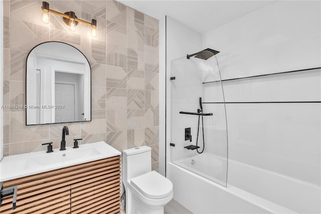 full bathroom with tile walls, decorative backsplash, washtub / shower combination, vanity, and toilet