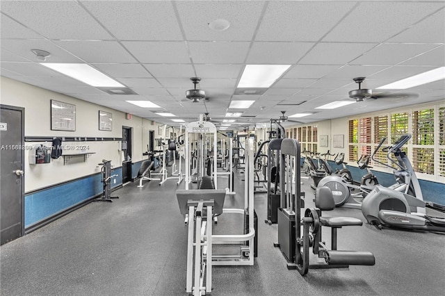 workout area with ceiling fan and a drop ceiling