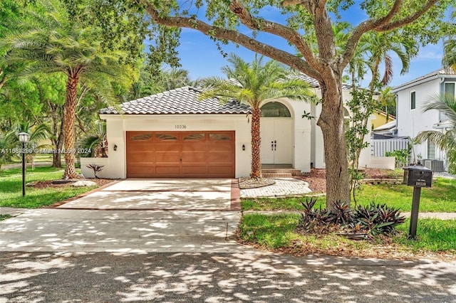 mediterranean / spanish-style home with a garage and central AC unit