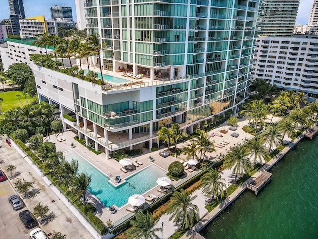 view of property with a community pool and a water view