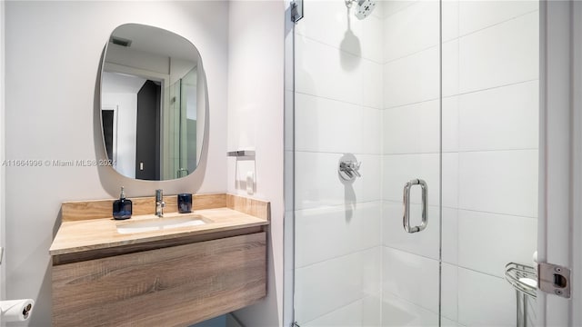 bathroom with vanity and a shower with shower door