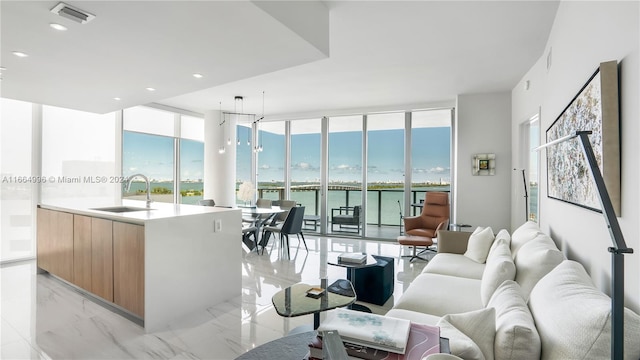 living room with a water view, sink, and expansive windows