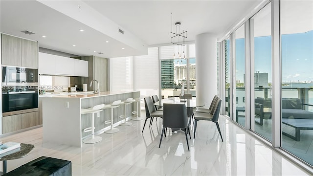 dining room with sink, a wall of windows, and a chandelier