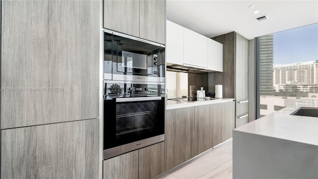 kitchen with white cabinetry, light tile patterned floors, and stainless steel appliances