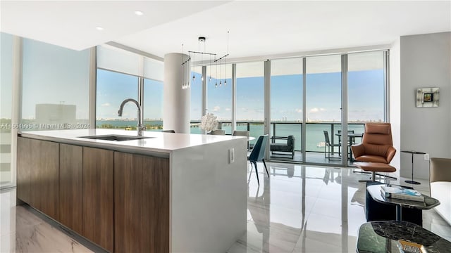 kitchen with a water view, floor to ceiling windows, sink, and a wealth of natural light