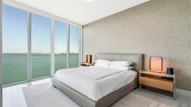 tiled bedroom with floor to ceiling windows and a water view