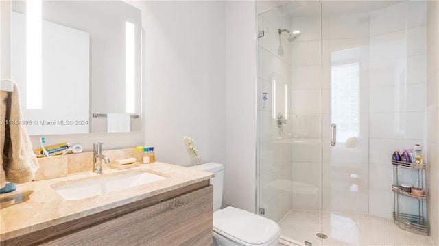 bathroom featuring vanity, toilet, and an enclosed shower