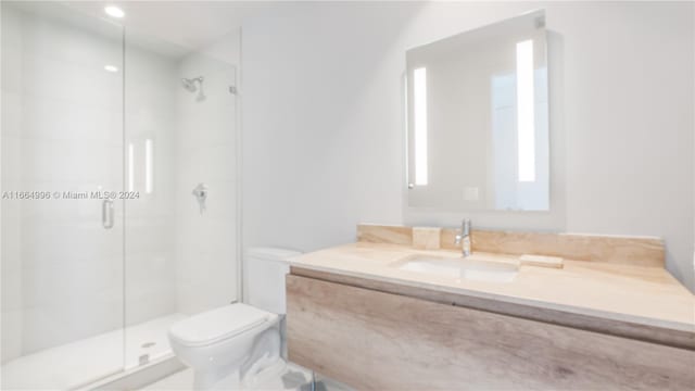 bathroom featuring walk in shower, vanity, and toilet