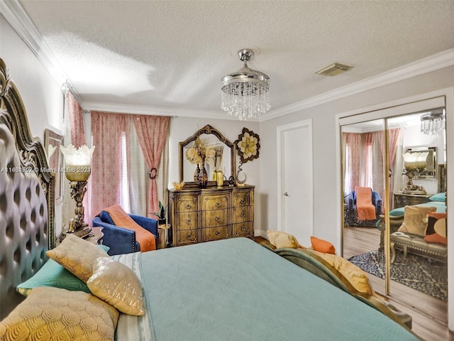 bedroom featuring wood-type flooring, a textured ceiling, a closet, and ornamental molding