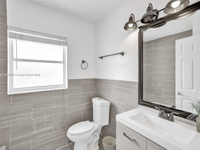 bathroom with tile walls, vanity, and toilet