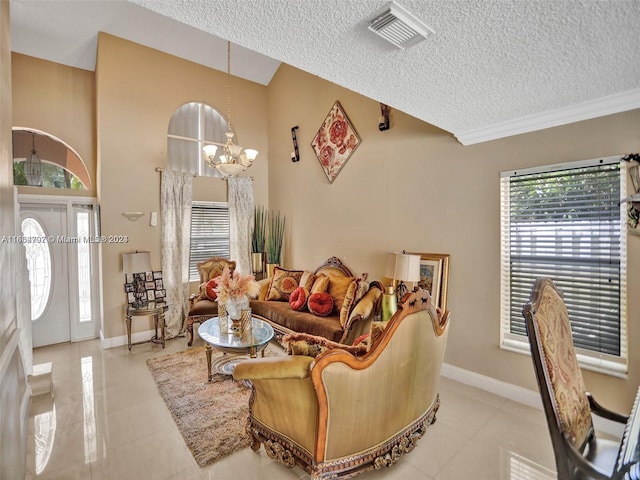 tiled living room featuring a textured ceiling, ornamental molding, and a notable chandelier