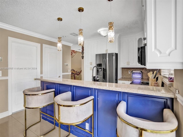 kitchen with hanging light fixtures, backsplash, white cabinetry, stainless steel appliances, and a breakfast bar area