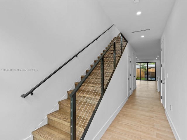 stairs with visible vents, baseboards, wood finished floors, and recessed lighting