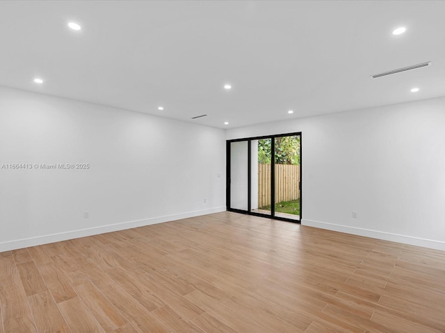 empty room with light wood-style floors, baseboards, and recessed lighting