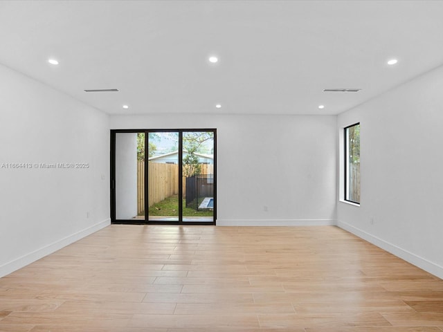 spare room featuring recessed lighting, a wealth of natural light, and light wood-style floors