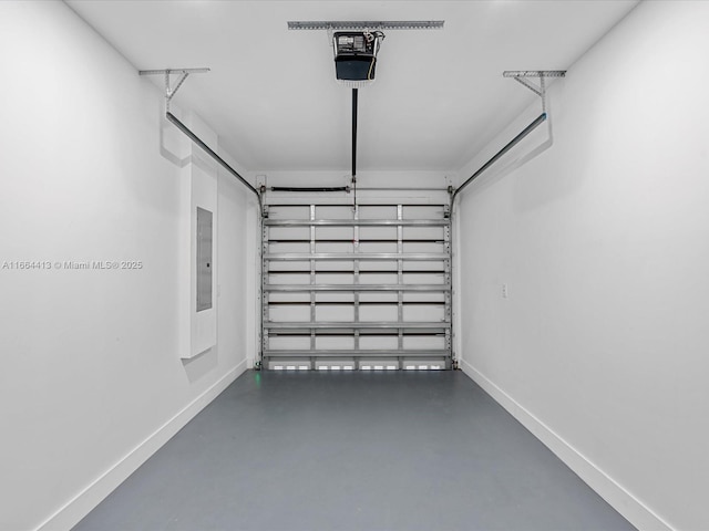 garage featuring a garage door opener, electric panel, and baseboards