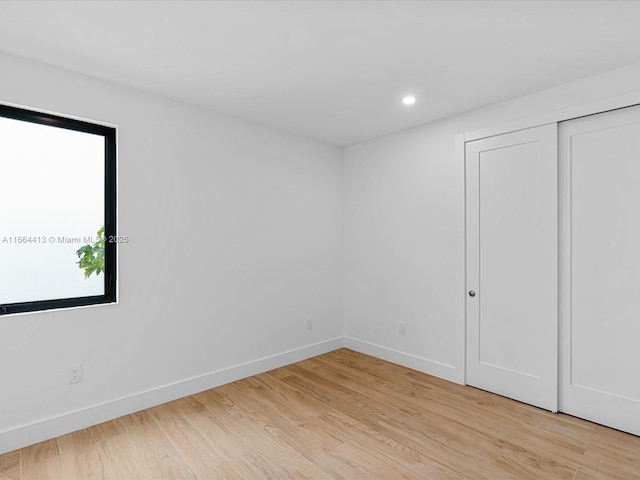 unfurnished bedroom with light wood-style floors, recessed lighting, a closet, and baseboards