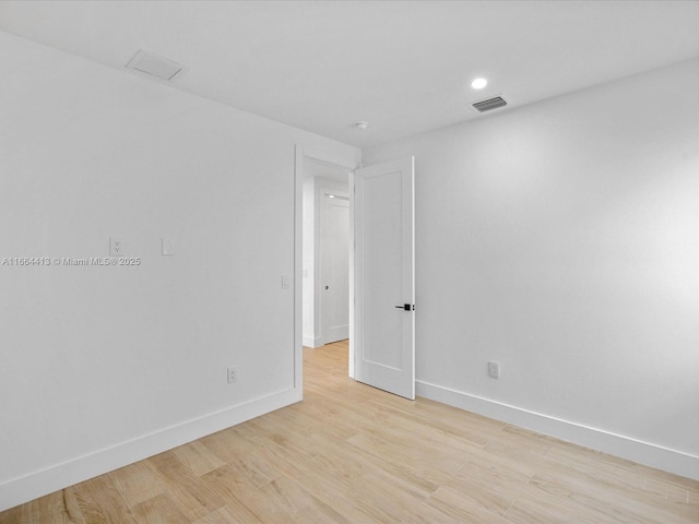 spare room featuring light wood finished floors, recessed lighting, visible vents, and baseboards