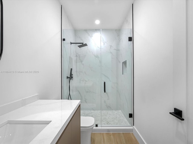 full bathroom with vanity, wood finished floors, a marble finish shower, and toilet