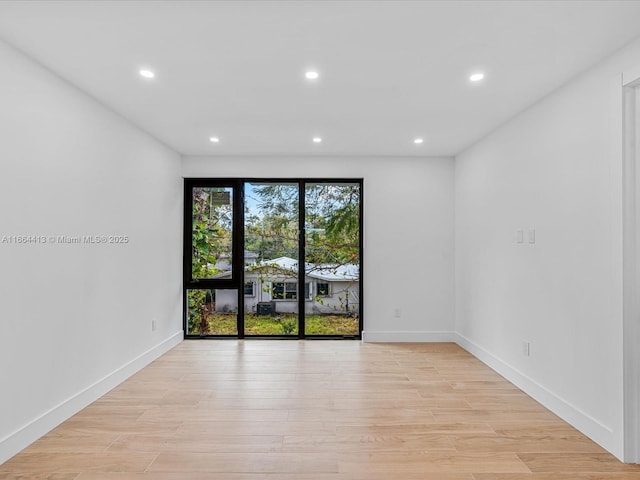 empty room featuring baseboards, recessed lighting, and light wood-style floors