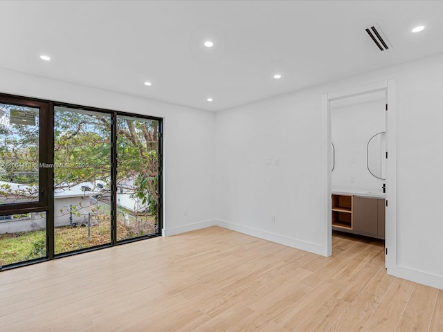 spare room featuring light wood-style flooring, visible vents, and recessed lighting