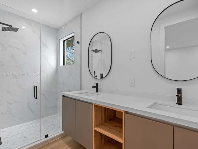 bathroom featuring double vanity, a sink, a marble finish shower, and recessed lighting