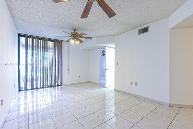 unfurnished room featuring light tile patterned floors, a textured ceiling, and a wall of windows