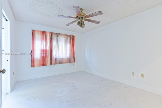 empty room with ceiling fan and a textured ceiling