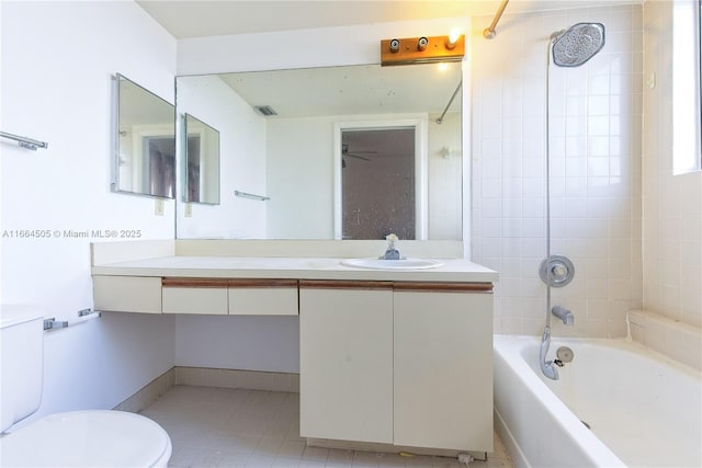 full bathroom featuring tiled shower / bath, vanity, and toilet