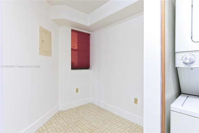 laundry area with stacked washer / dryer and electric panel