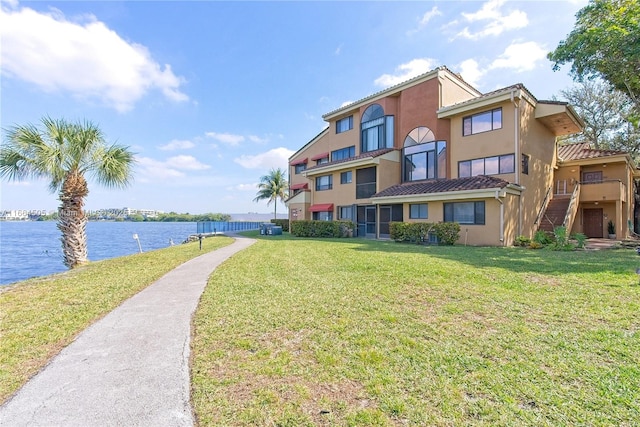 view of home's community featuring a water view and a lawn