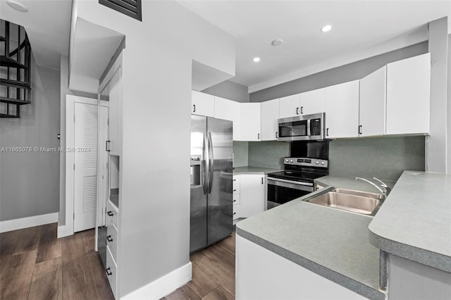 kitchen featuring dark hardwood / wood-style flooring, white cabinetry, sink, and stainless steel appliances