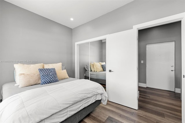 bedroom with dark hardwood / wood-style flooring and a closet