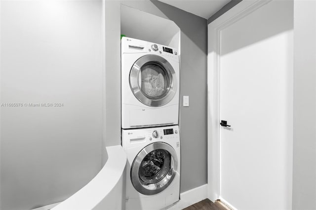 clothes washing area with dark hardwood / wood-style floors and stacked washer / dryer