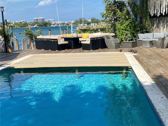 view of swimming pool with outdoor lounge area and a deck with water view