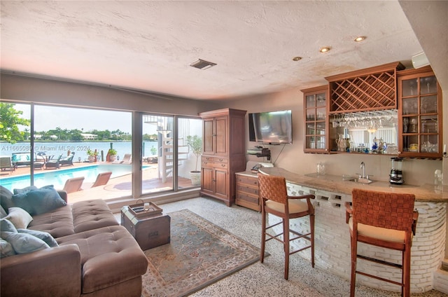 living room with a textured ceiling and wet bar