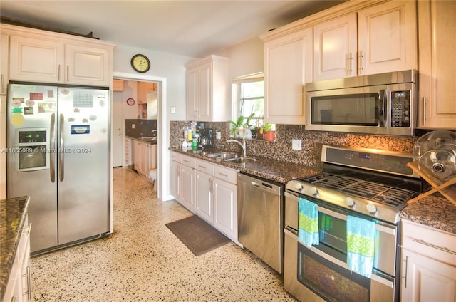 kitchen featuring dark stone counters, sink, and stainless steel appliances