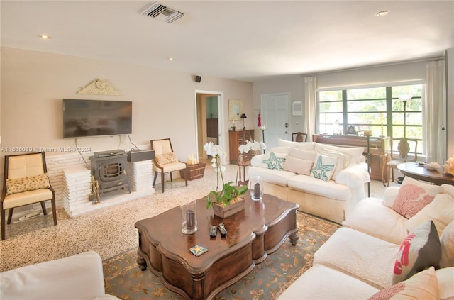 carpeted living room featuring a wood stove