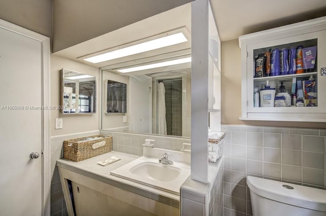 bathroom featuring tile walls, vanity, and toilet