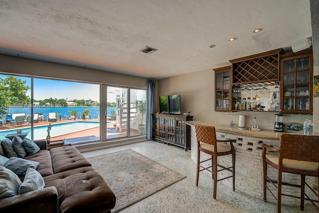 living room with a textured ceiling and bar