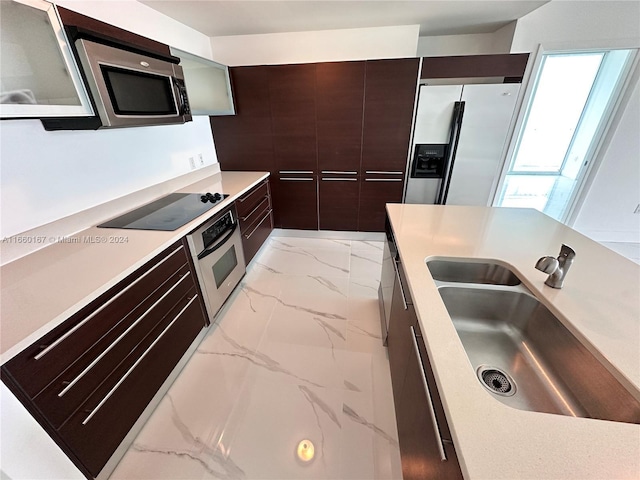 kitchen with sink, stainless steel appliances, and dark brown cabinets