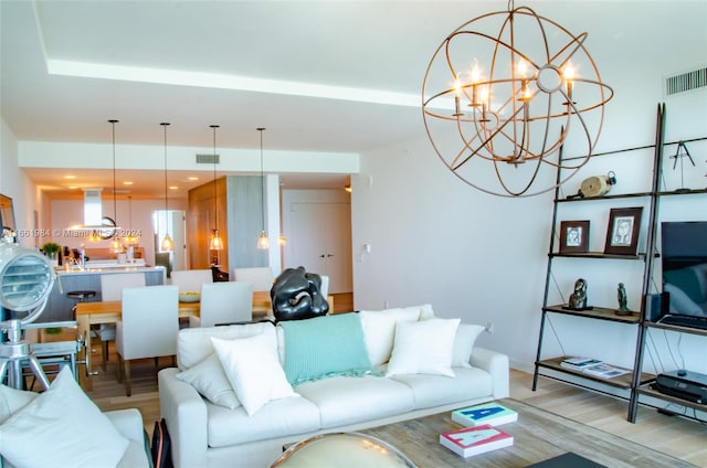 living room featuring light wood-type flooring and a chandelier