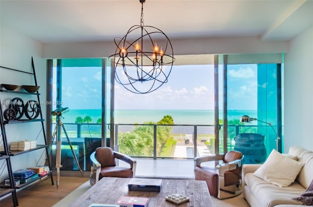 living room with wood-type flooring, a chandelier, and a water view