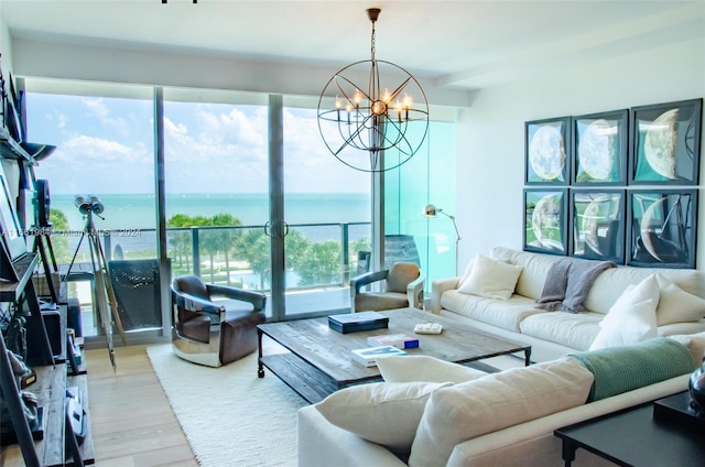 living room featuring wood-type flooring, a water view, and a notable chandelier