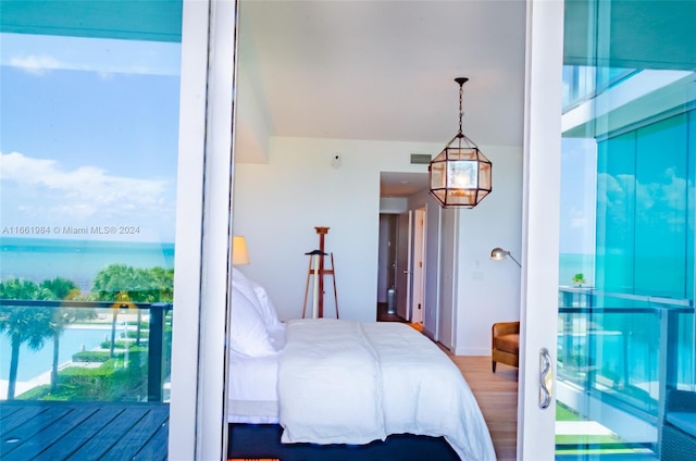 bedroom with wood-type flooring and a water view