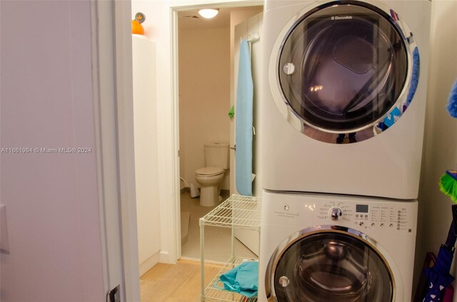 laundry room featuring stacked washer / dryer and light tile patterned floors